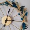 Horloge murale géométrique dorée et fleurs séchées