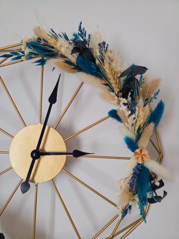 Horloge murale géométrique dorée et fleurs séchées